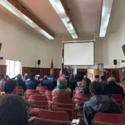 Lamuen Margarita Milanca al cierre del Encuentro Medioambiental de la Provincia de Llanquihue. Está en el salón municipal y un grupo de personas, sentadas en silla, la escucha.