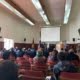 Lamuen Margarita Milanca al cierre del Encuentro Medioambiental de la Provincia de Llanquihue. Está en el salón municipal y un grupo de personas, sentadas en silla, la escucha.