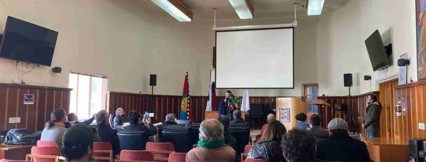 Lamuen Margarita Milanca al cierre del Encuentro Medioambiental de la Provincia de Llanquihue. Está en el salón municipal y un grupo de personas, sentadas en silla, la escucha.