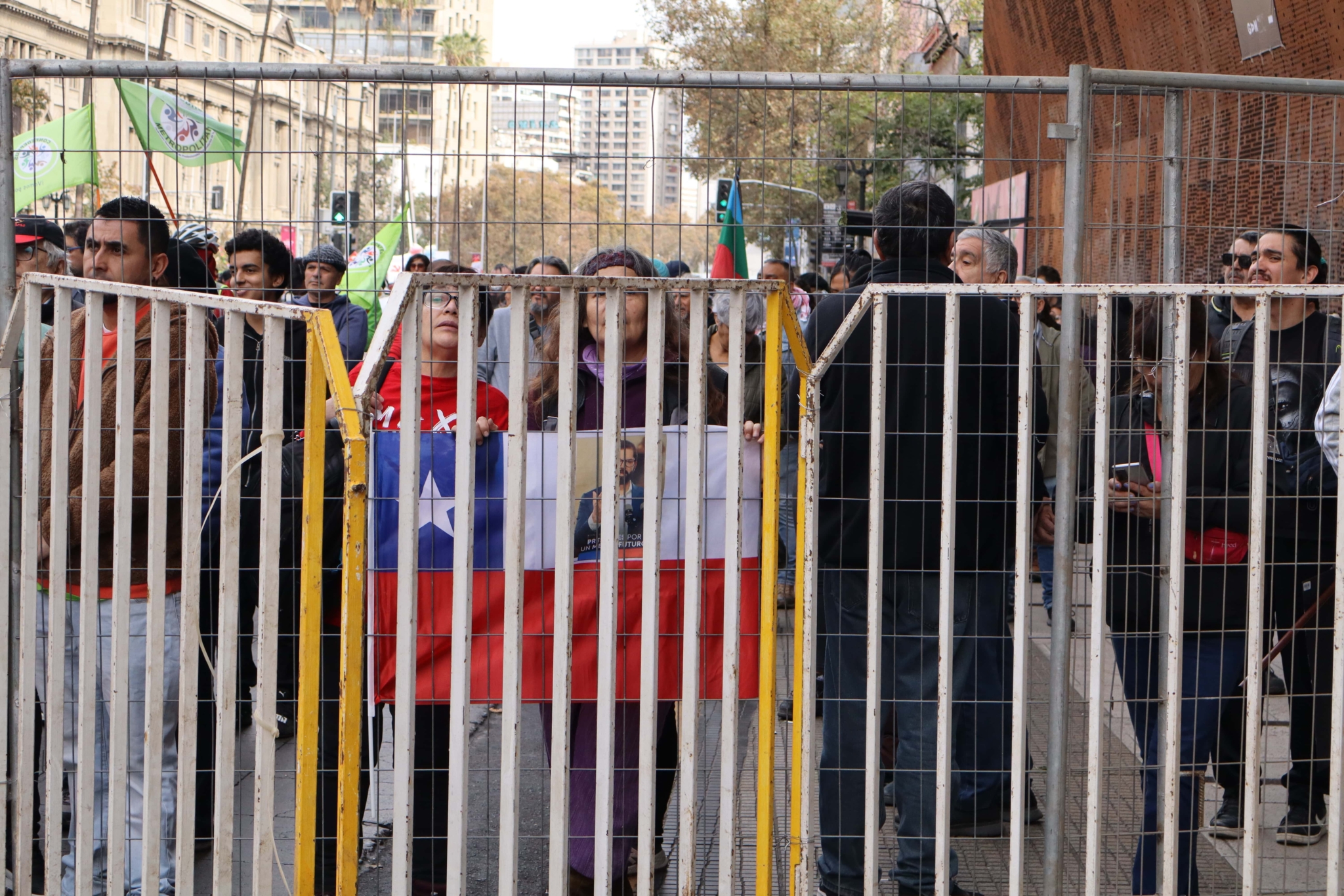mujer tras reja sosteniendo bandera de Chile 1 de mayo.