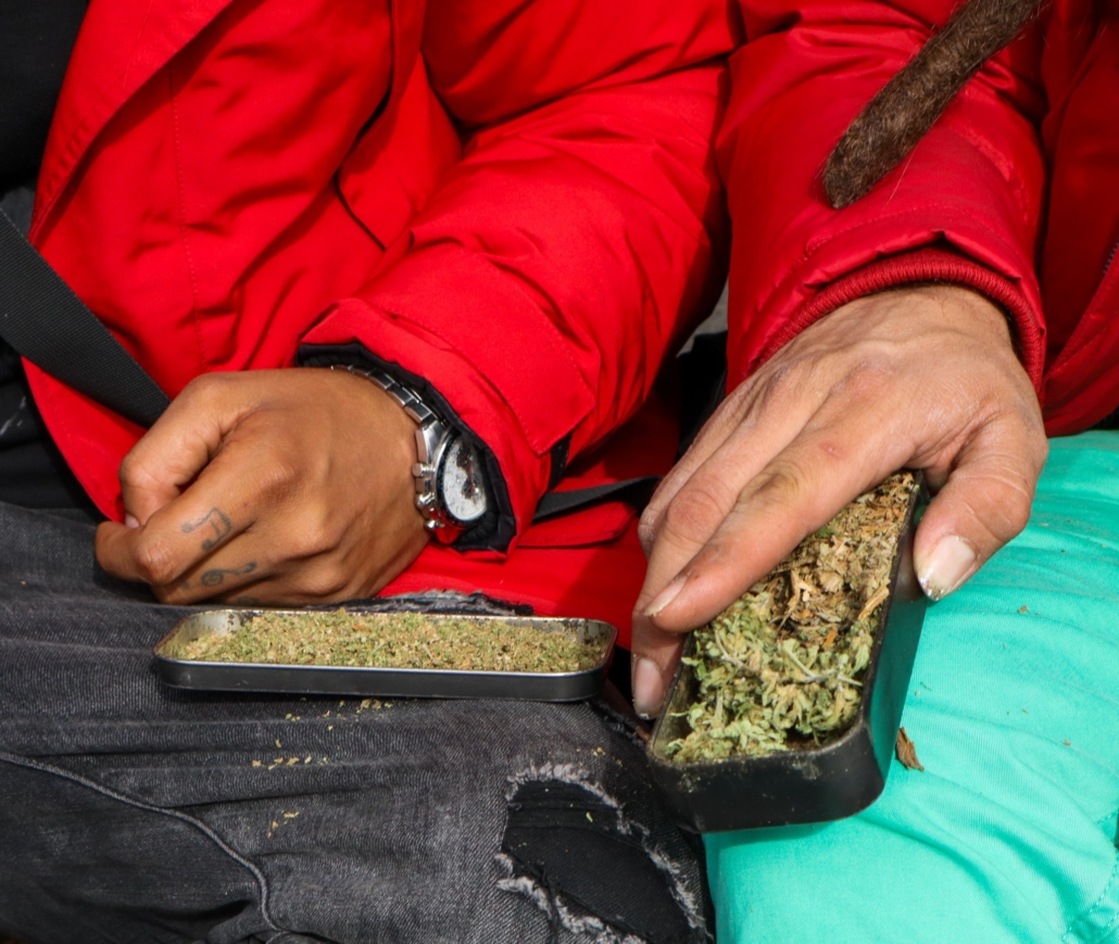 asistentes a la marcha preparando un pito de marihuana 