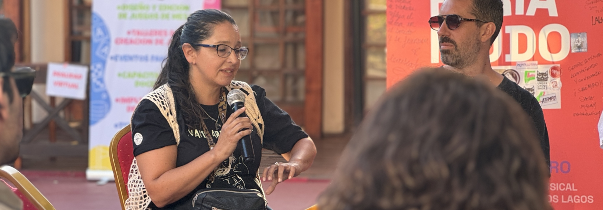 Feria MUDO: conversatorios para profesionalizar la escena musical. Fotografía de Paola Vásquez exponiendo en panel de industria musical.